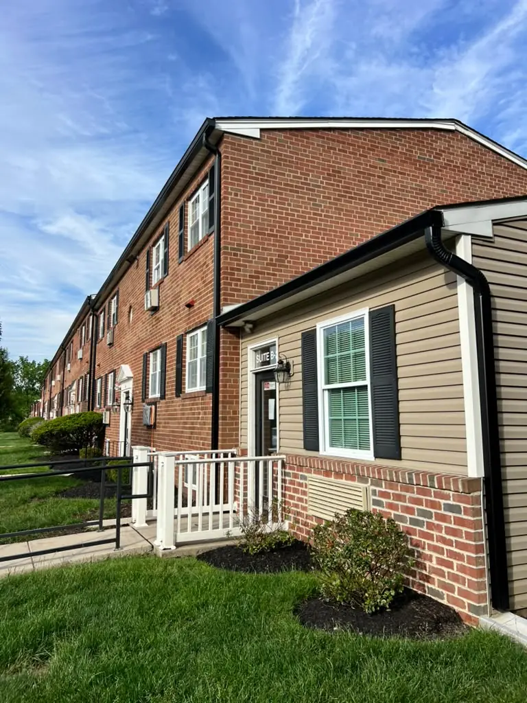 Black seamless gutters and downspouts on a brick apartment building