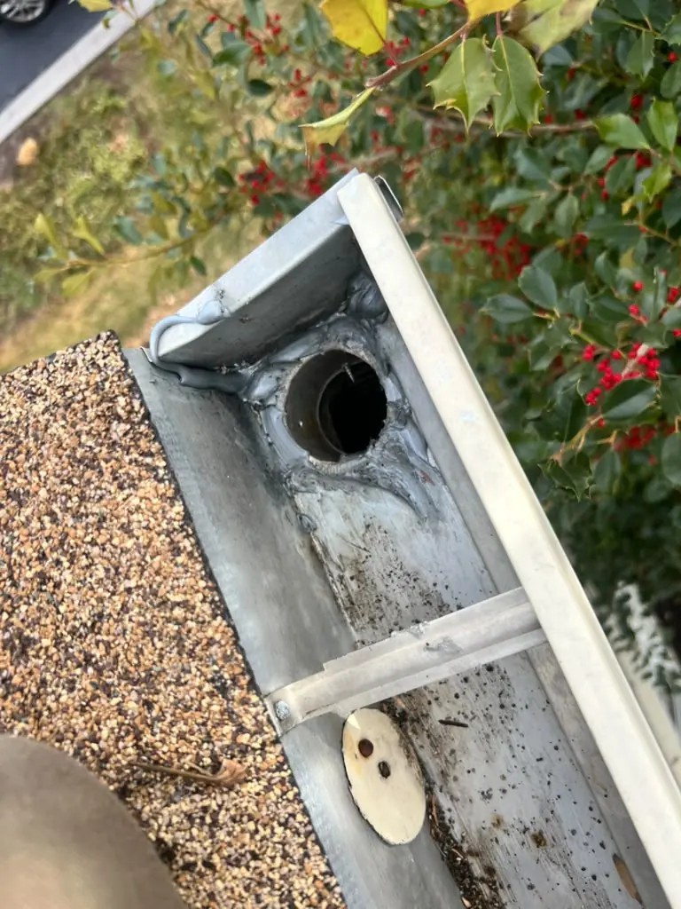 The same gutter outlet cleared and flowing again