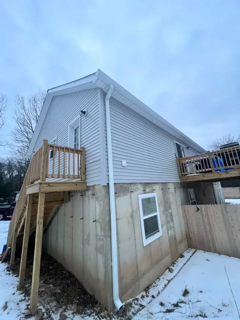 New downspout carrying water to grade on a home with a walk-out basement
