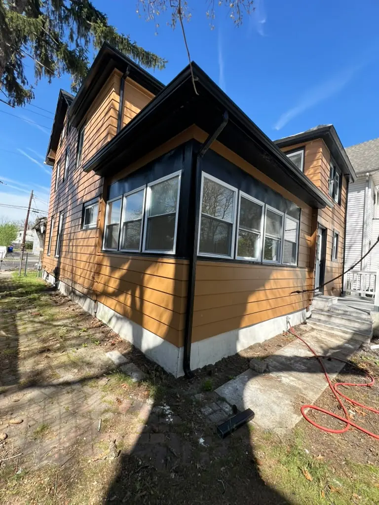 New siding and black seamless gutters on a corner restoration
