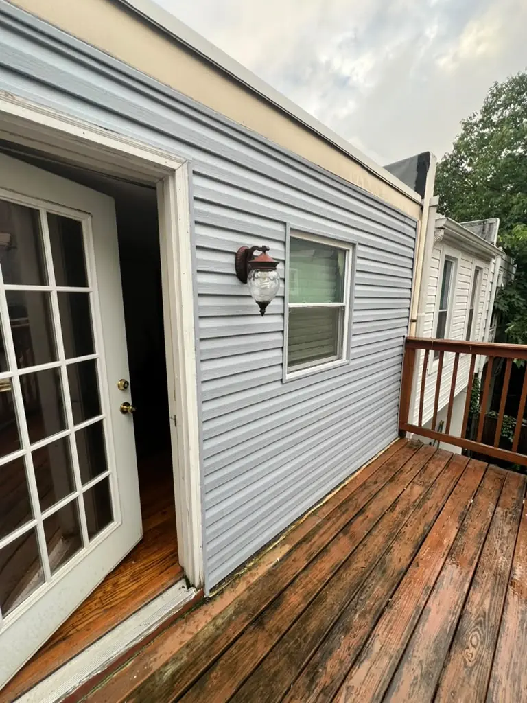 Light blue vinyl siding beside a rear deck